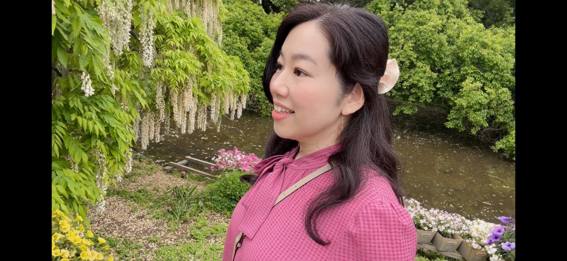 藤棚の前で微笑む松崎恵子さん